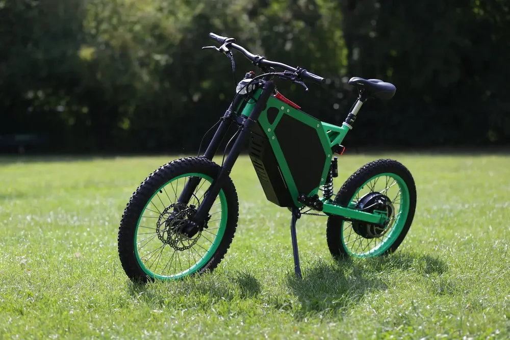 alaria X3 Pro 5kw Electric Bike transitioning from urban street to a light off-road trail in Europe.